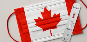 A Covid-19 test cassette on top of a face mask imprinted with the Canadian flag
